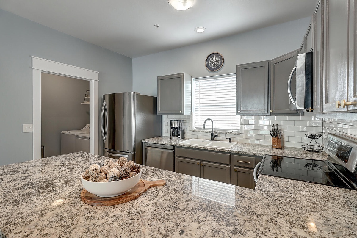 Cook your favorite meals in this modern kitchen with granite countertops, stainless steel appliances, and everything you need for a comfortable stay.