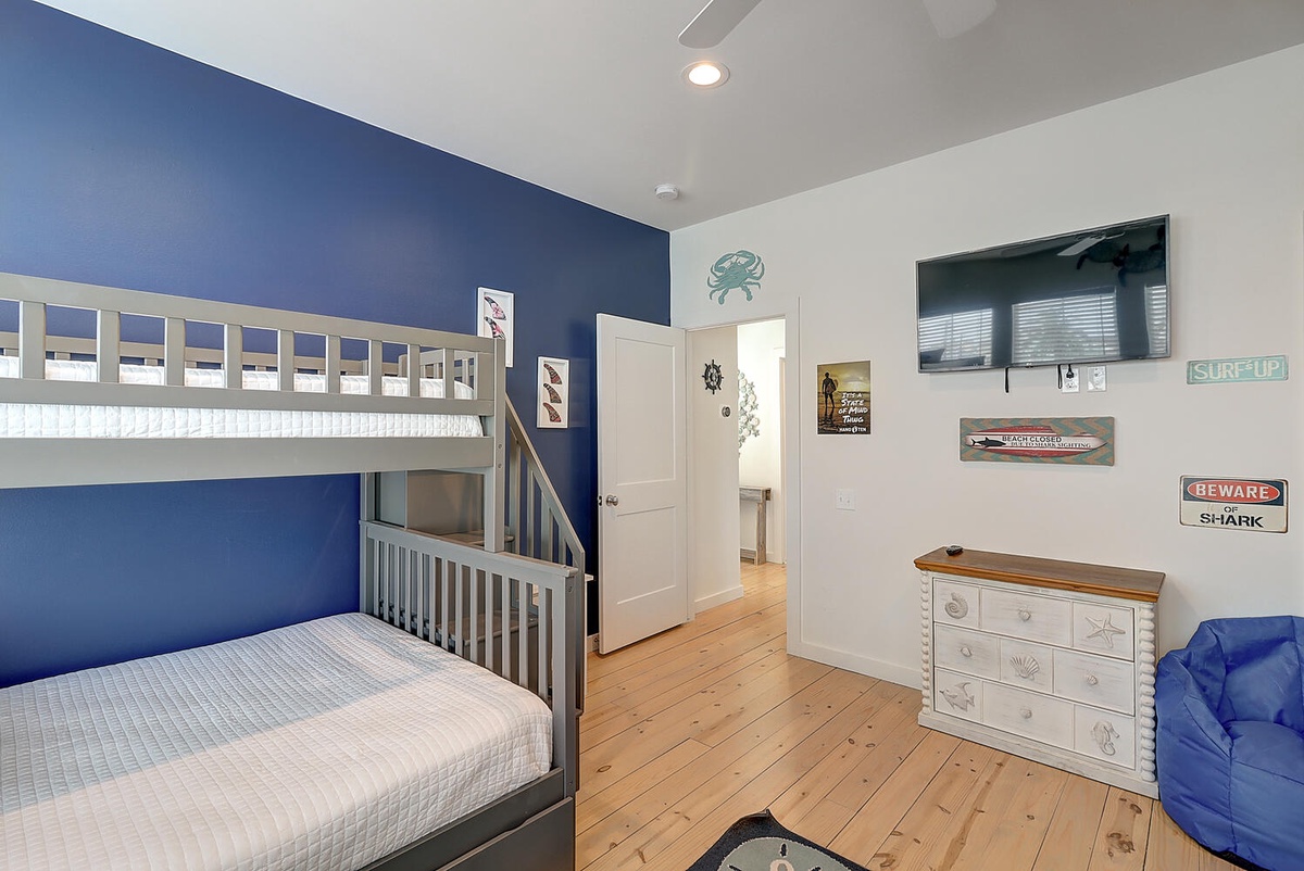 Your kids will love this nautical-themed bunk room with ocean decor, TV for movie nights, and cozy seating.