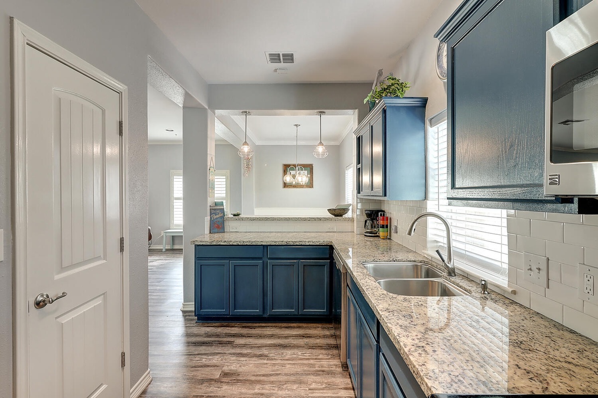 Your spacious kitchen features granite countertops, rich blue cabinetry, and everything you need to create memorable meals during your stay.