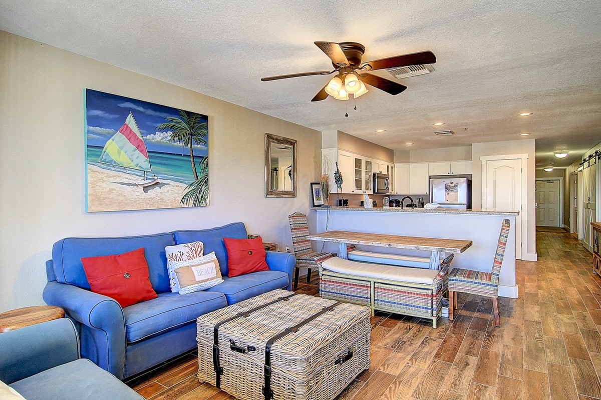 Unwind in this bright, coastal-themed living space where beach vibes and comfortable seating create your perfect vacation retreat.