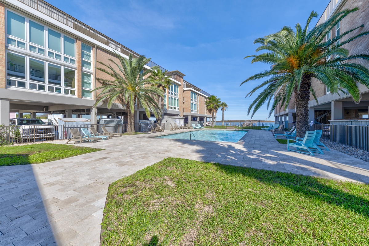 Dive into your private oasis surrounded by swaying palms, where sparkling blue waters meet coastal comfort in this tropical poolside paradise.