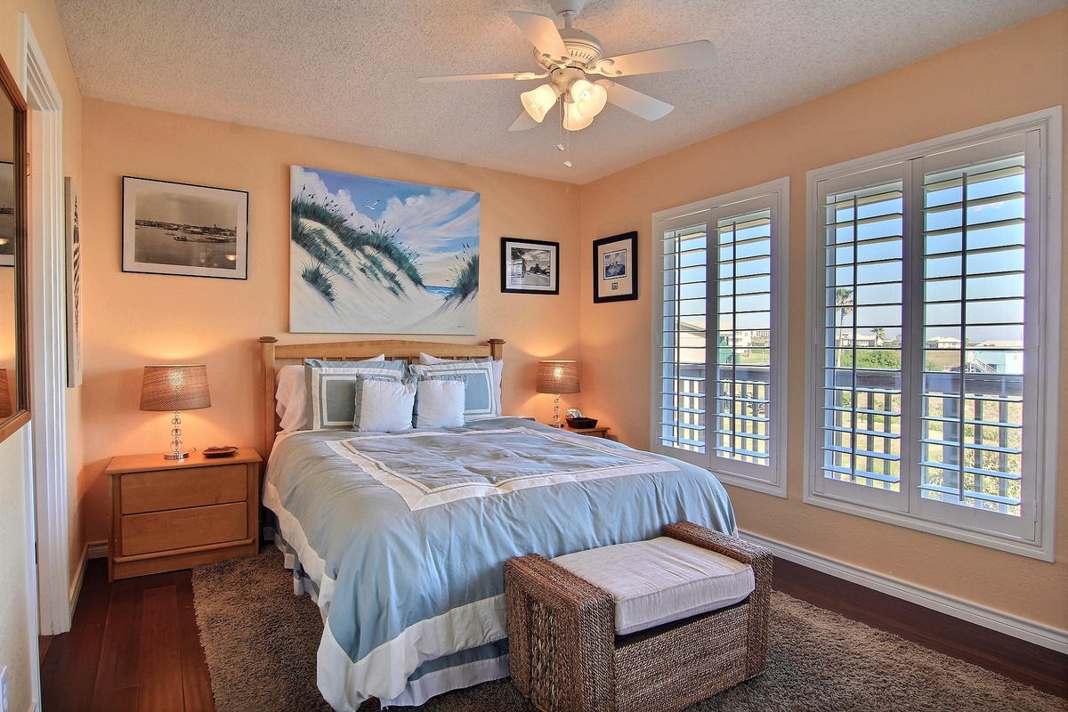 Wake up refreshed in this coastal-themed bedroom where ocean breezes flow through plantation shutters and peaceful artwork sets the mood for your perfect getaway.