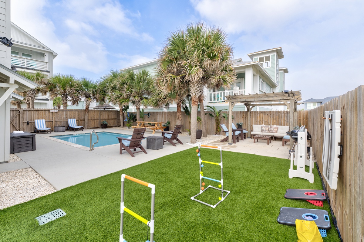 Your private backyard oasis awaits with sparkling pool, game lawn, and tropical palms - perfect for family fun and relaxation.