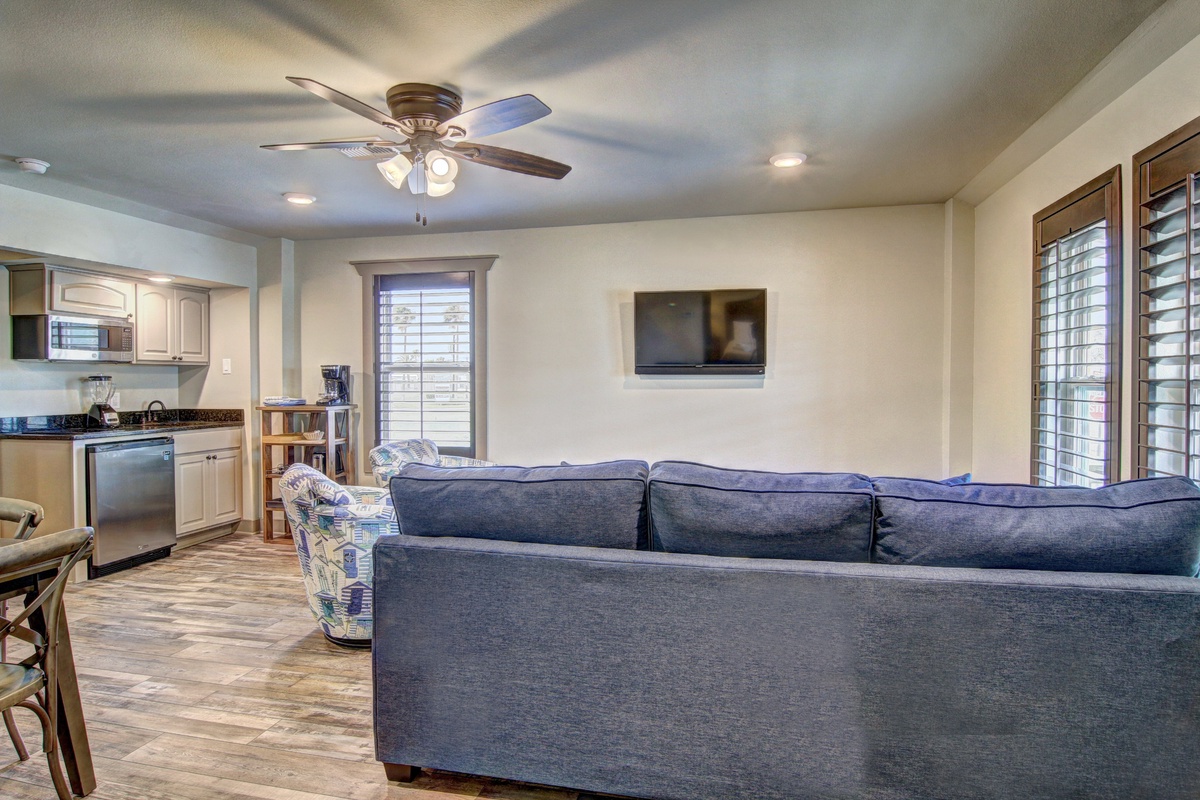 Sink into plush blue seating while the ceiling fan keeps you cool. Your open-concept space flows from kitchen to living room perfectly.