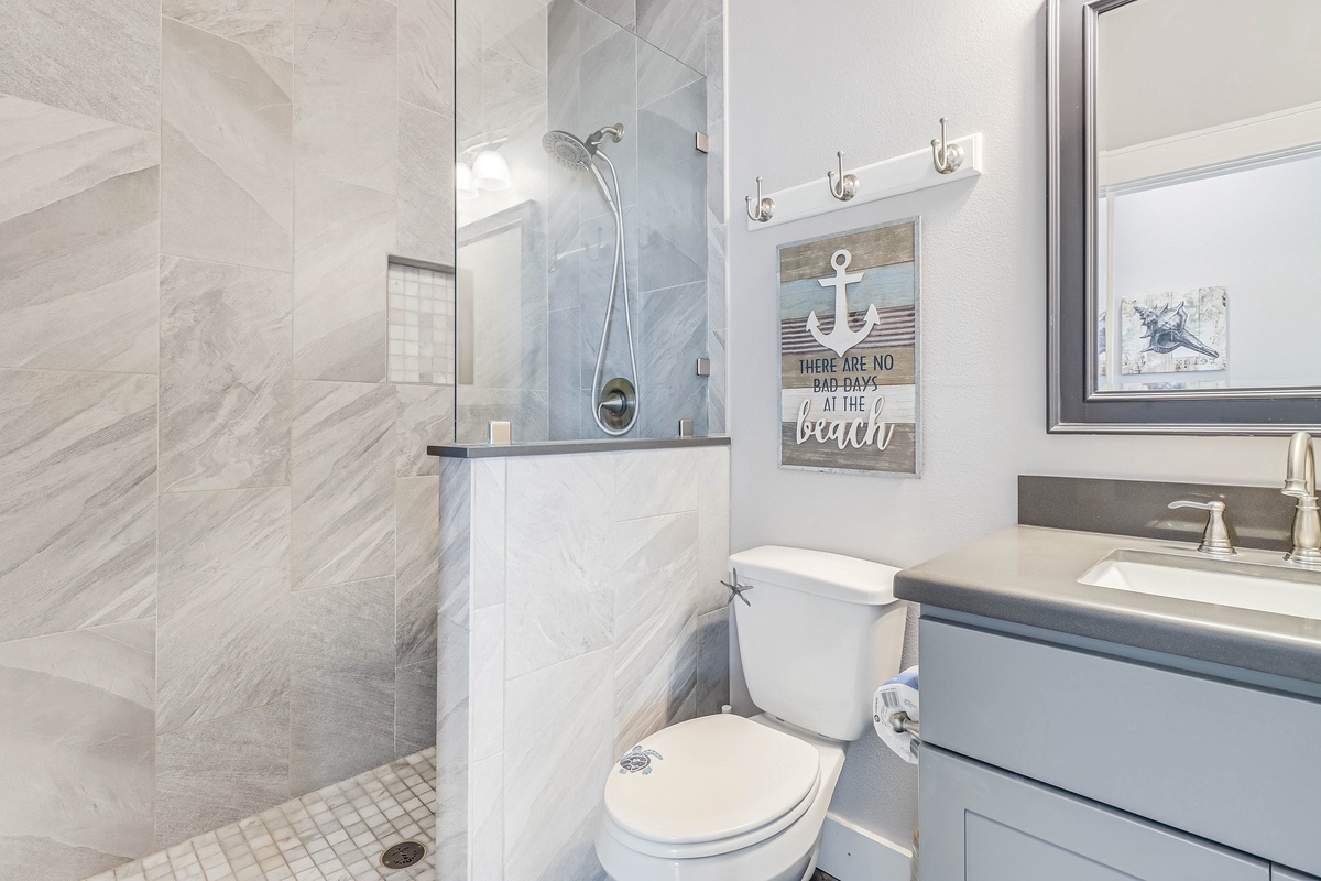Unwind in your elegant marble bathroom featuring a luxurious walk-in shower and coastal-themed touches that make every moment feel like a retreat.