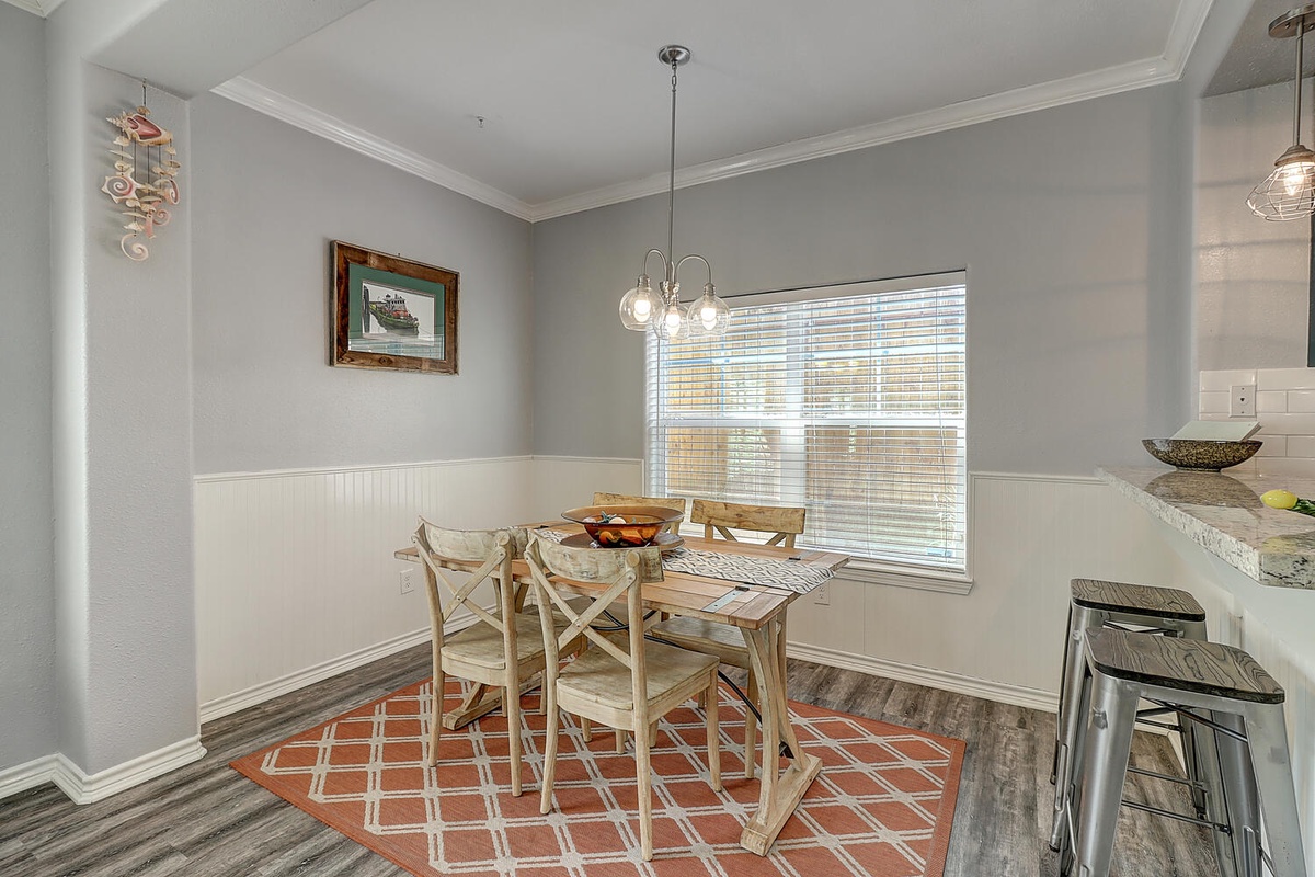 Gather around your charming dining table for memorable meals, bathed in natural light from the large window.
