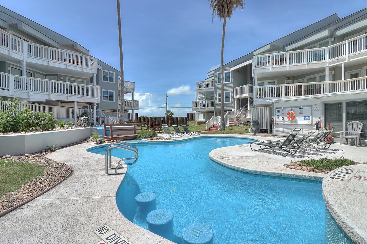 Dive into your private oasis with this sparkling pool surrounded by comfortable loungers, perfect for soaking up the sun between beach adventures.