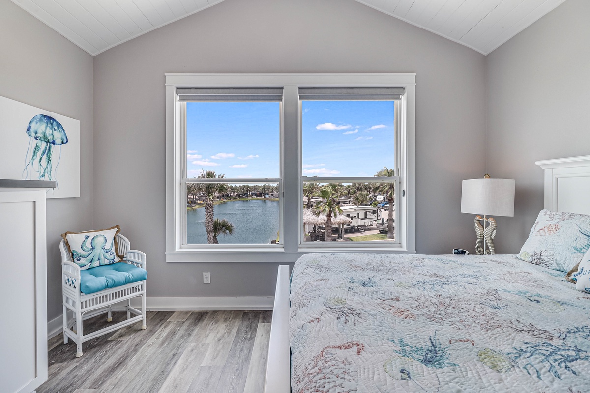 Wake up to stunning water views from your bright bedroom, where coastal-themed decor perfectly complements the serene lagoon scenery outside your window.
