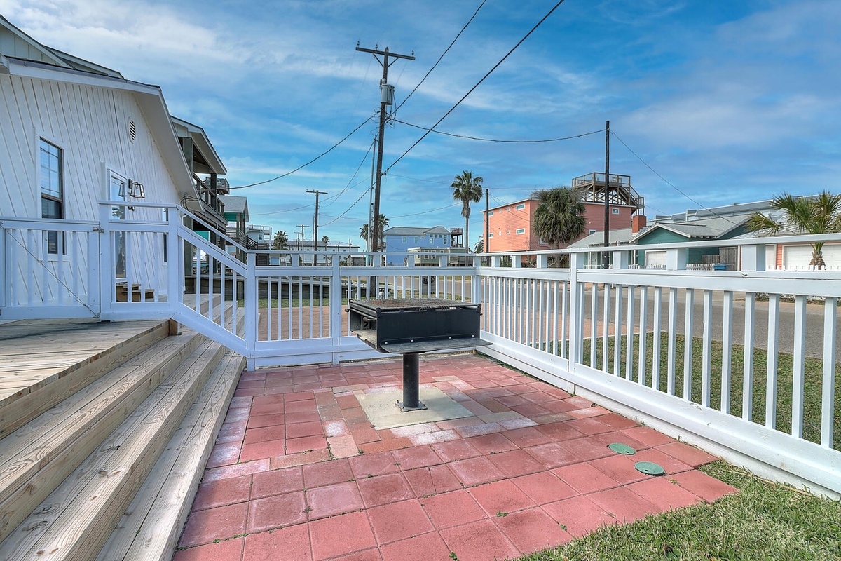 Your private outdoor space features a charcoal grill ready for beachside barbecues and coastal dining under sunny skies.