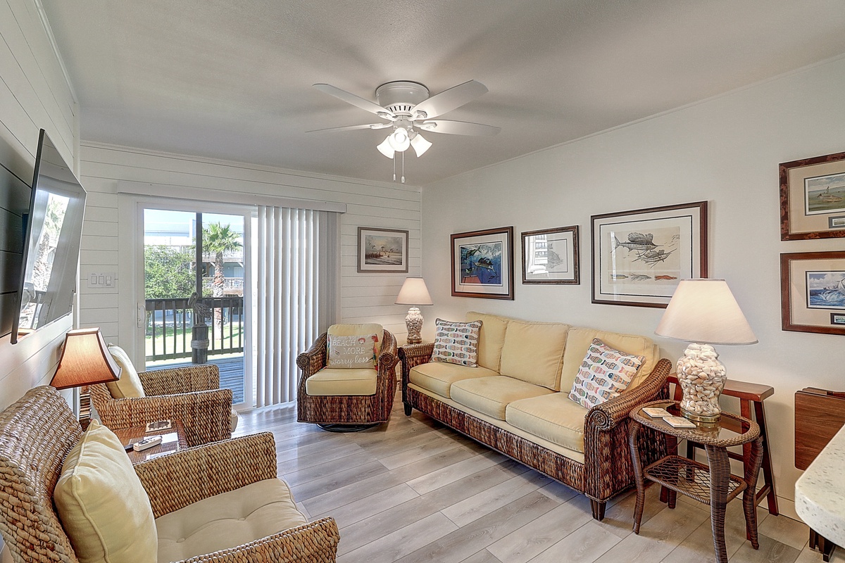 Relax in your coastal-inspired living room with wicker furniture and framed artwork, perfect for unwinding after beach days.