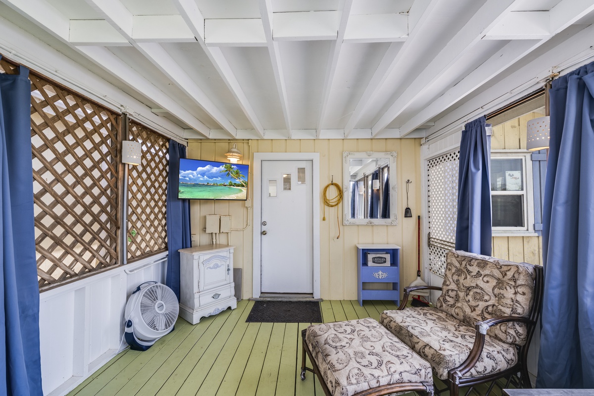 Settle into your own private screened porch, where coastal charm meets comfort. Relax in the vintage armchair, enjoy the breeze, and let the cheerful tropical artwork transport you to paradise.