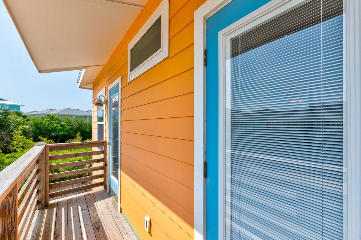 Step onto your private balcony and feel the gentle breeze through the wooden deck, where vibrant turquoise and orange colors welcome you.