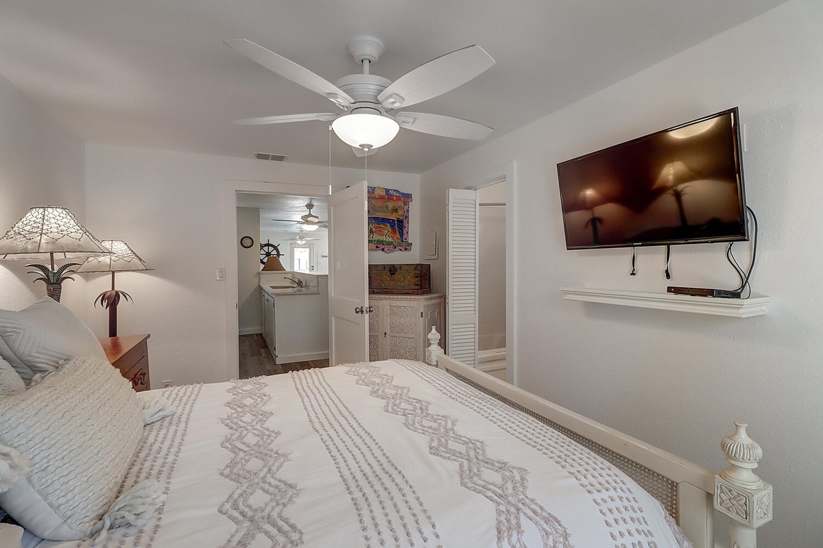 Drift off to sleep in your cozy bedroom, where soft bedding meets modern comfort under a gentle ceiling fan breeze.