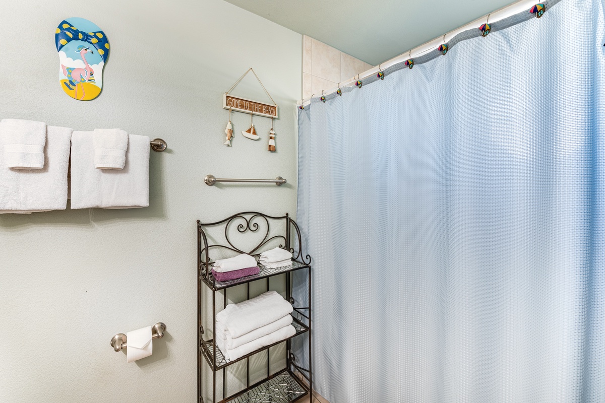 You'll love the thoughtful touches in this bathroom, from fluffy towels to charming nautical decor that makes every morning feel special.