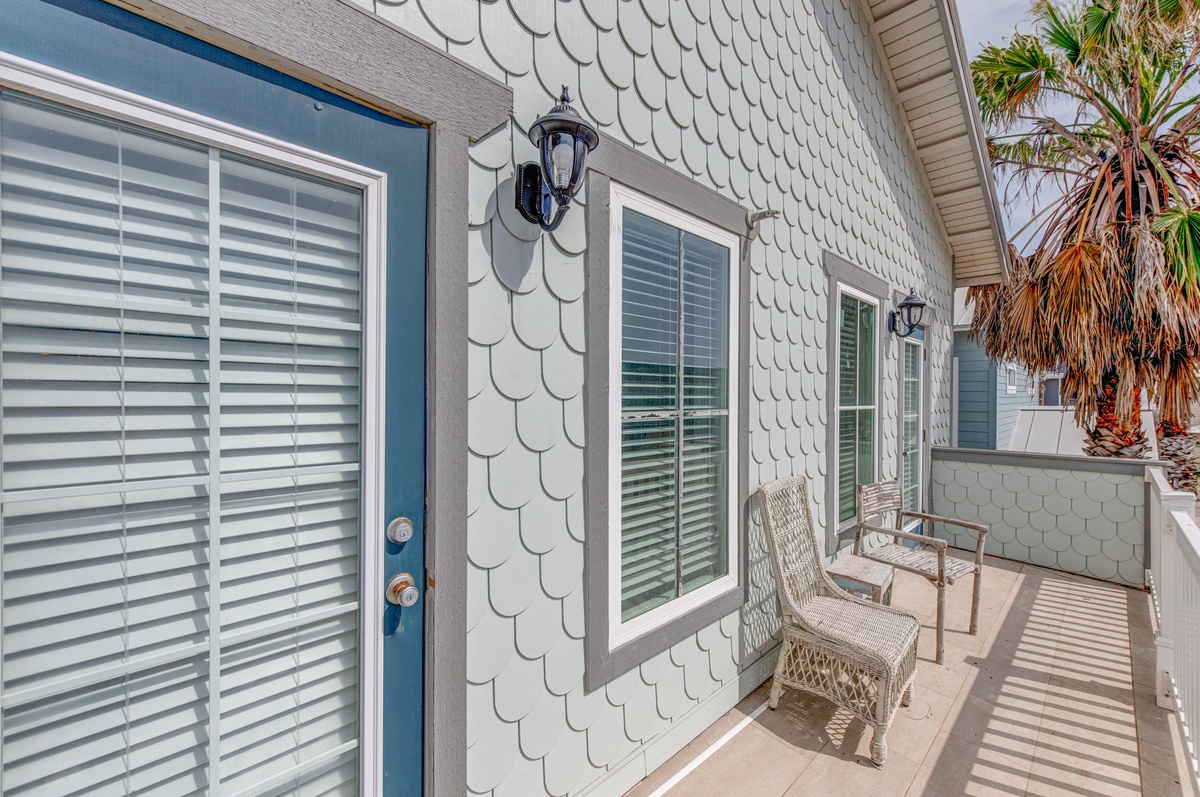 Welcome to your charming coastal retreat! Step onto the private balcony where wicker seating awaits under swaying palm fronds.