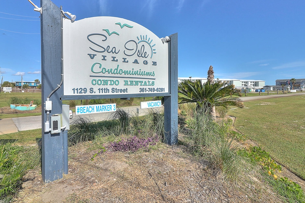 Sea Isle Village entrance sign welcomes visitors to beachfront condominium rentals in a coastal setting.