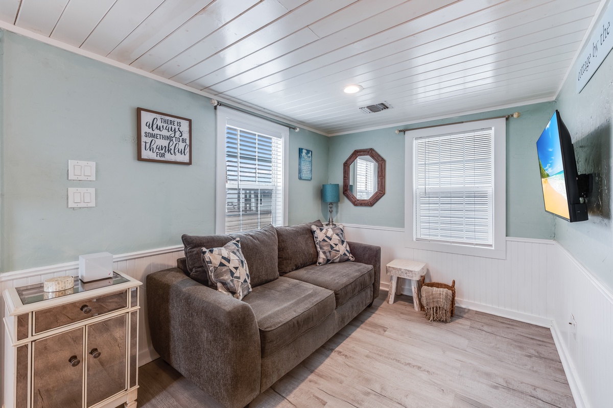 Sink into the plush gray sofa and enjoy your favorite shows on the wall-mounted TV in this cozy living space.