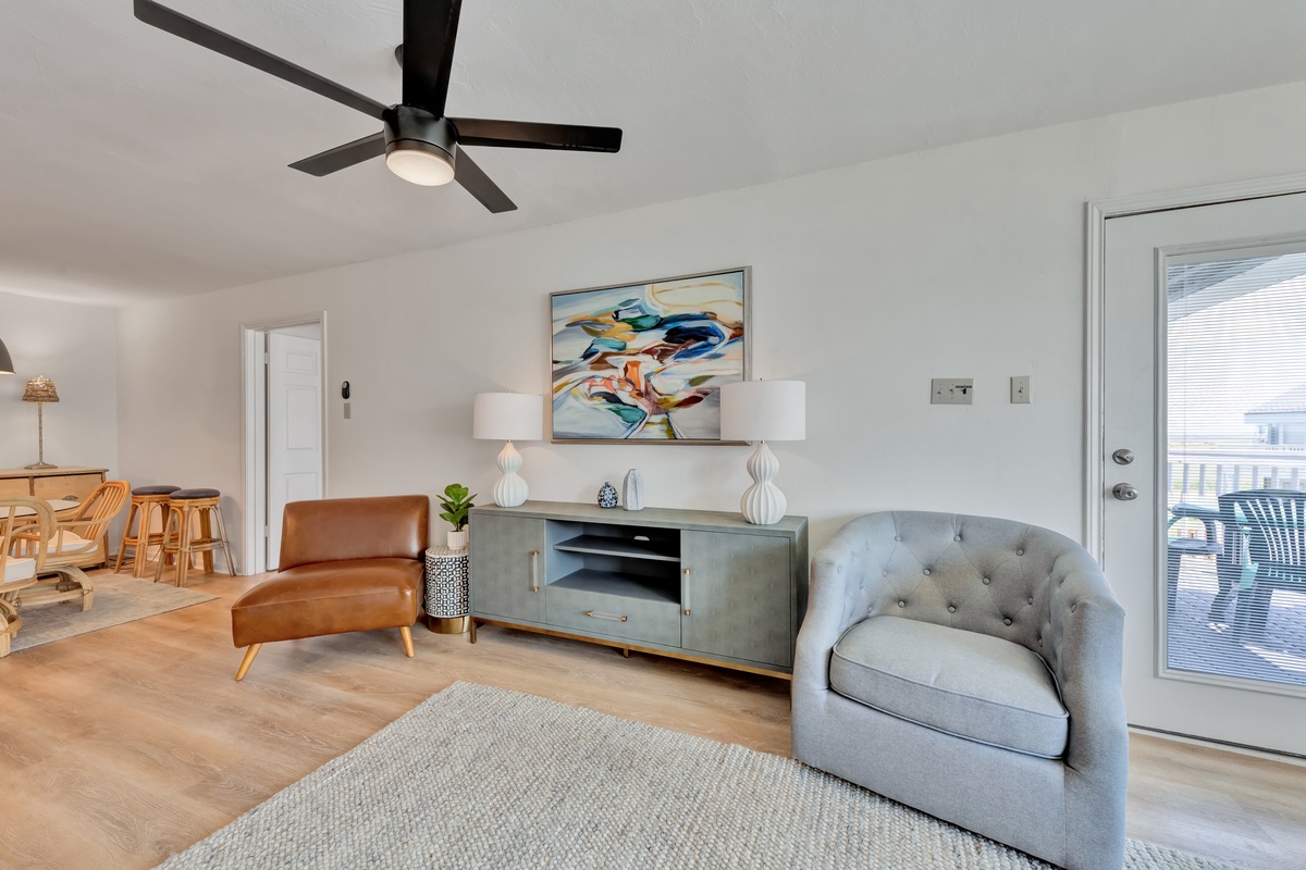 Relax in your stylish living room where modern comfort meets warm design, complete with cozy seating and gentle ceiling fan breezes.