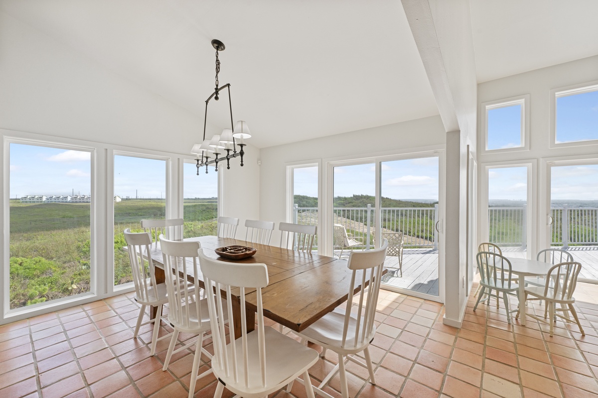 Gather around your expansive dining table with panoramic windows framing endless coastal views—the perfect spot for memorable meals together.