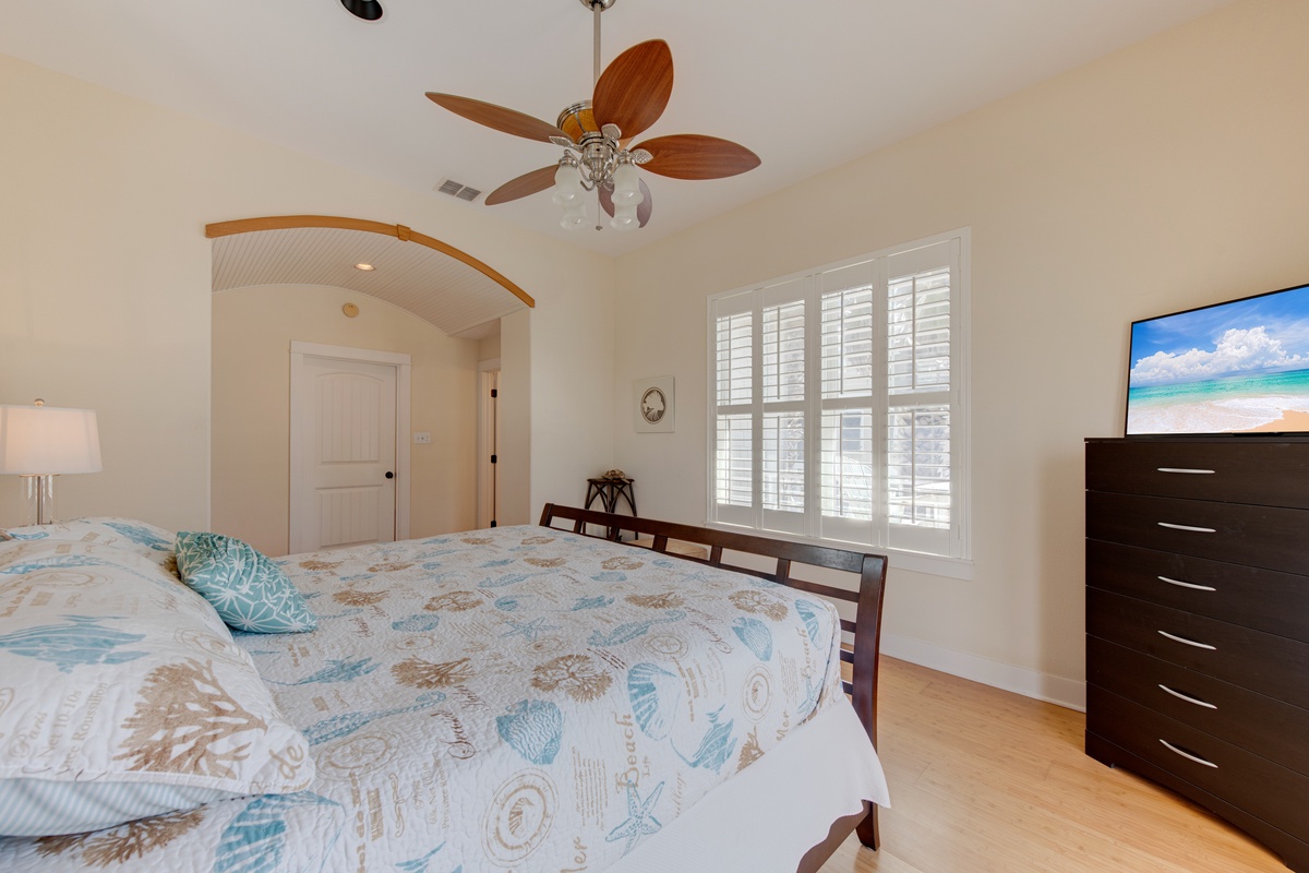 Sleep peacefully in your coastal-themed bedroom with tropical ceiling fan and ocean-inspired bedding creating a soothing retreat.
