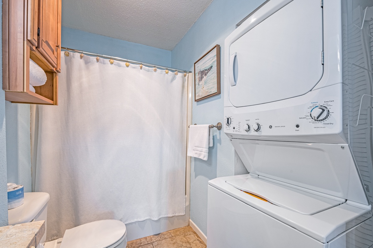 Your private bathroom features a convenient stacked washer-dryer combo, perfect for refreshing your wardrobe during extended stays.