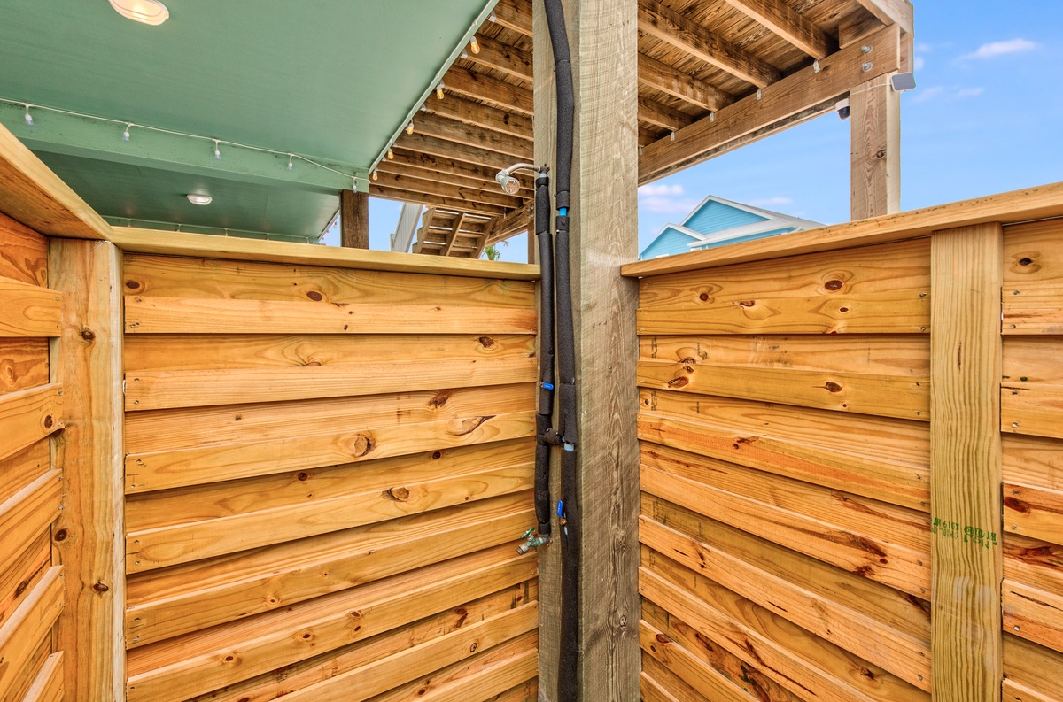 Enjoy your private outdoor shower oasis surrounded by beautiful cedar fencing, combining rustic charm with open-air relaxation under the sky.