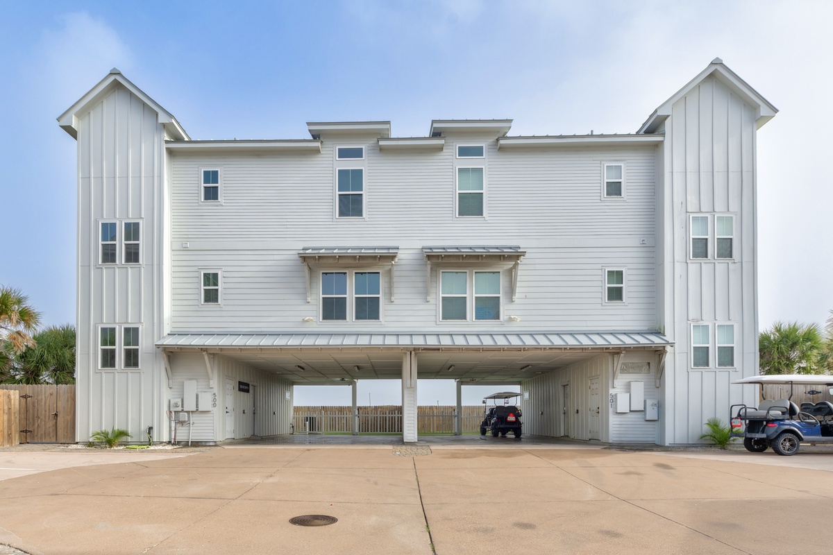 Modern coastal duplex with covered parking and tropical palms, just steps from the beach in a peaceful residential setting.