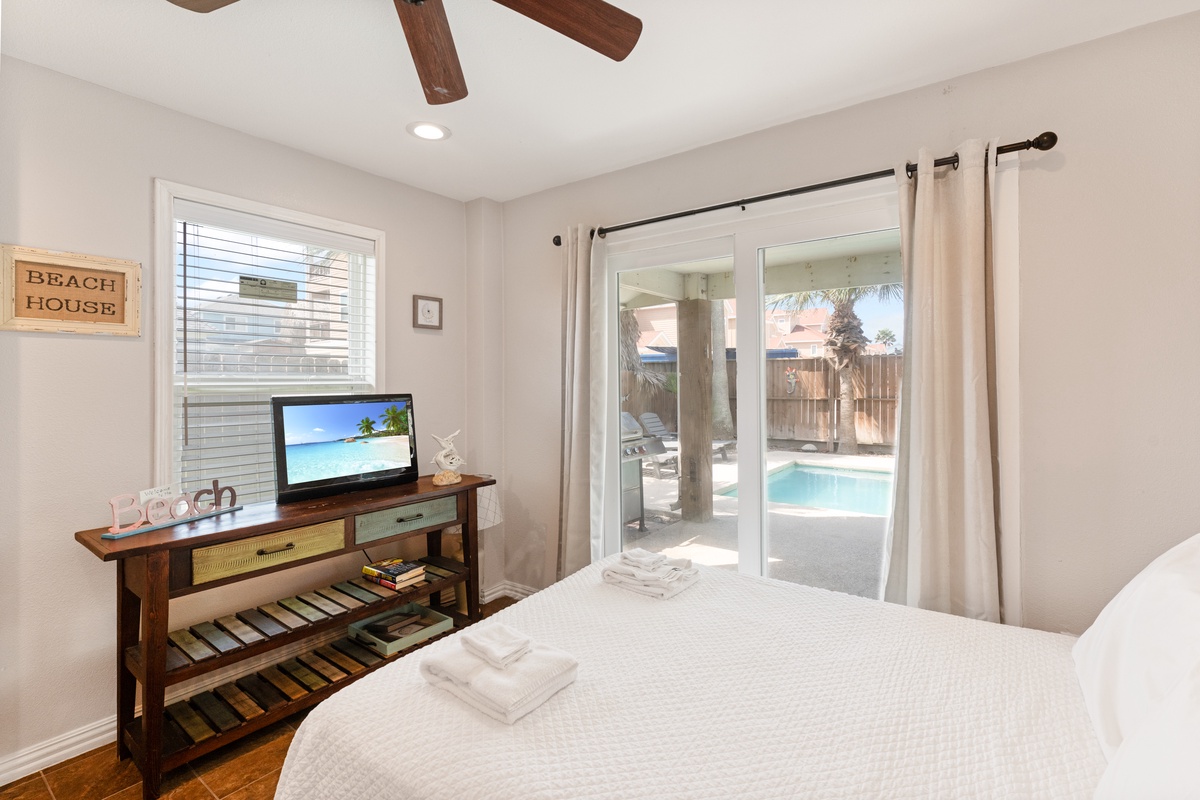 Wake up to tranquil pool views from your cozy bedroom, where coastal decor and modern comfort create your perfect retreat.
