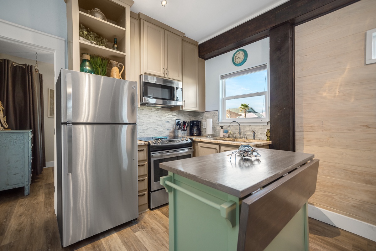 Step into your fully equipped kitchen where rustic beams meet modern convenience, perfect for preparing meals with stainless steel appliances and charming details.