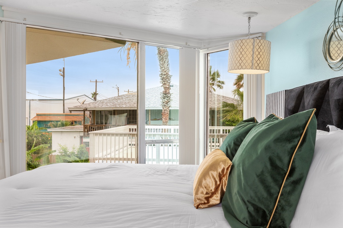 Wake up to tropical views and coastal charm in your bright bedroom with emerald accents and natural light.