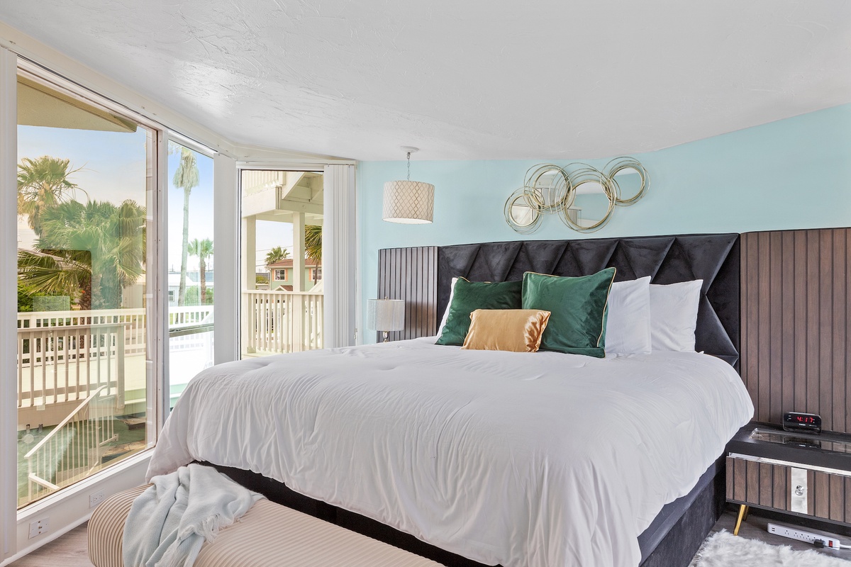 Wake up to tropical palm views from your stylish bedroom, where crisp linens and coastal decor create the perfect peaceful retreat.