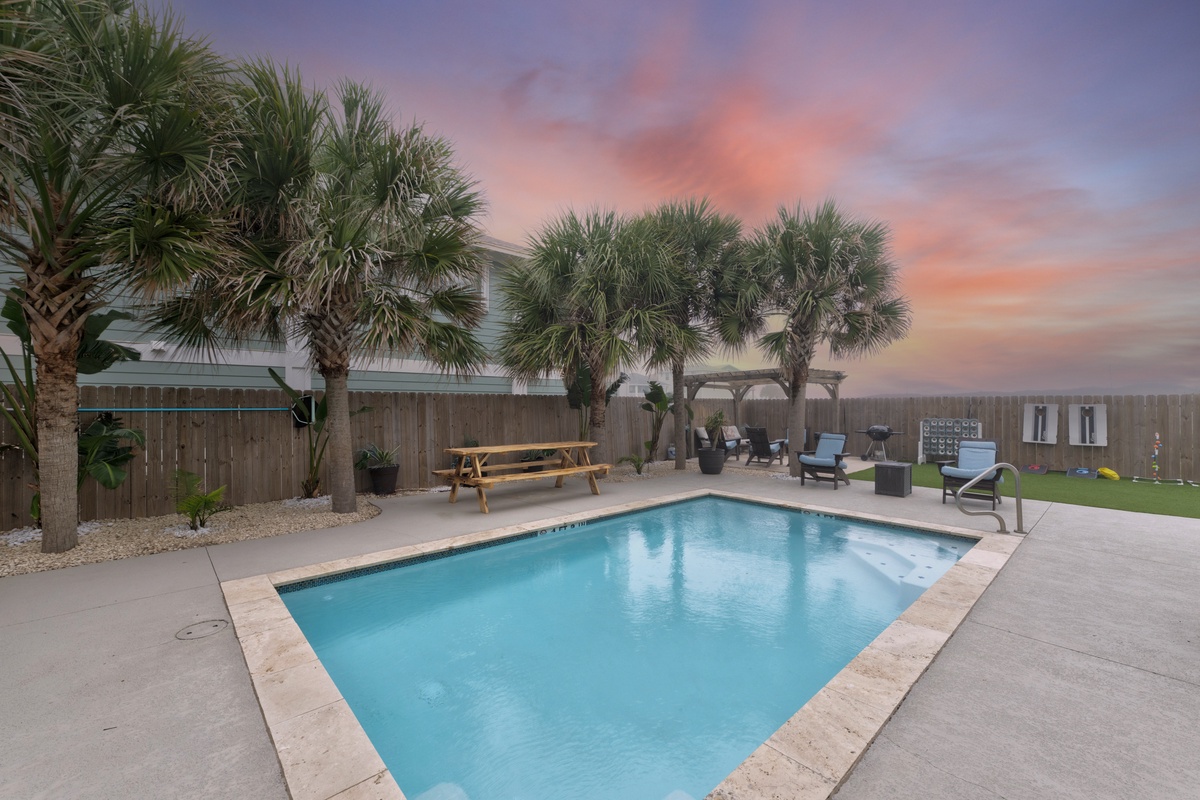 Private pool oasis surrounded by swaying palm trees, perfect for evening swims under spectacular sunset skies.