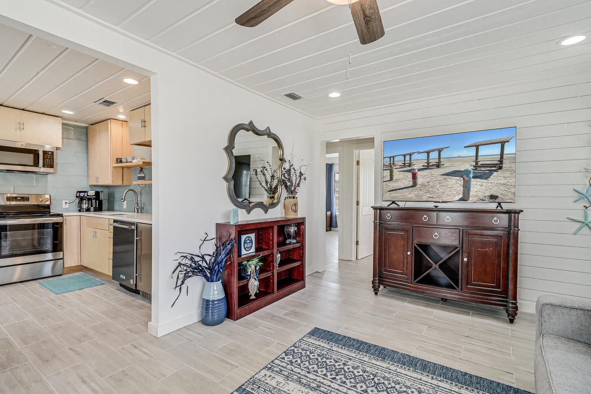 Unwind in your bright, coastal-inspired living space where shiplap walls and warm wood beams create the perfect backdrop for relaxing evenings.