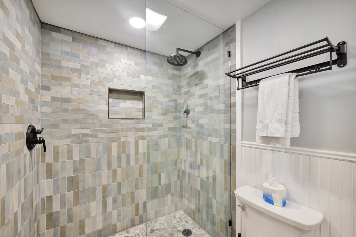 Step into your private spa-like shower with beautiful mosaic tile walls and rainfall showerhead for the ultimate relaxation.