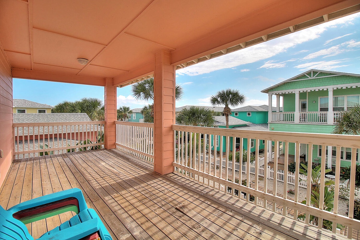 Step onto your covered balcony where coastal breezes flow through while you sip morning coffee overlooking charming beach houses and swaying palms.