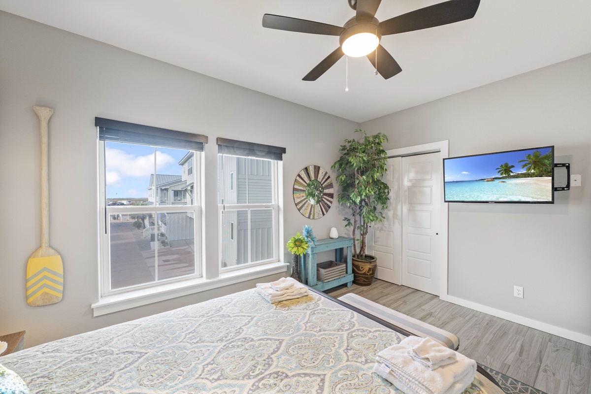 Your peaceful bedroom features a ceiling fan for comfort and large windows flooding the space with natural light.