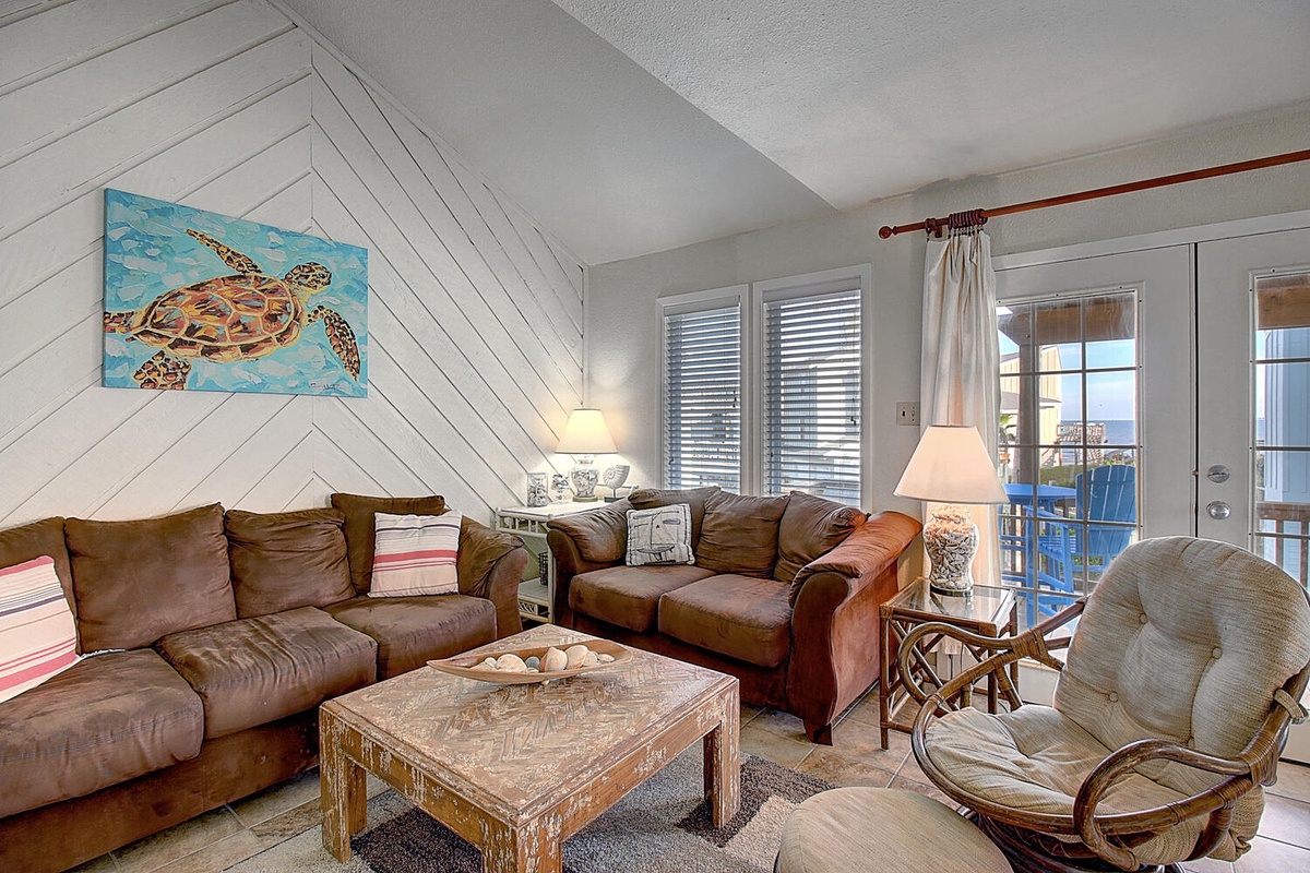 Relax in this cozy coastal living room with plush leather seating and charming sea turtle artwork welcoming you home.