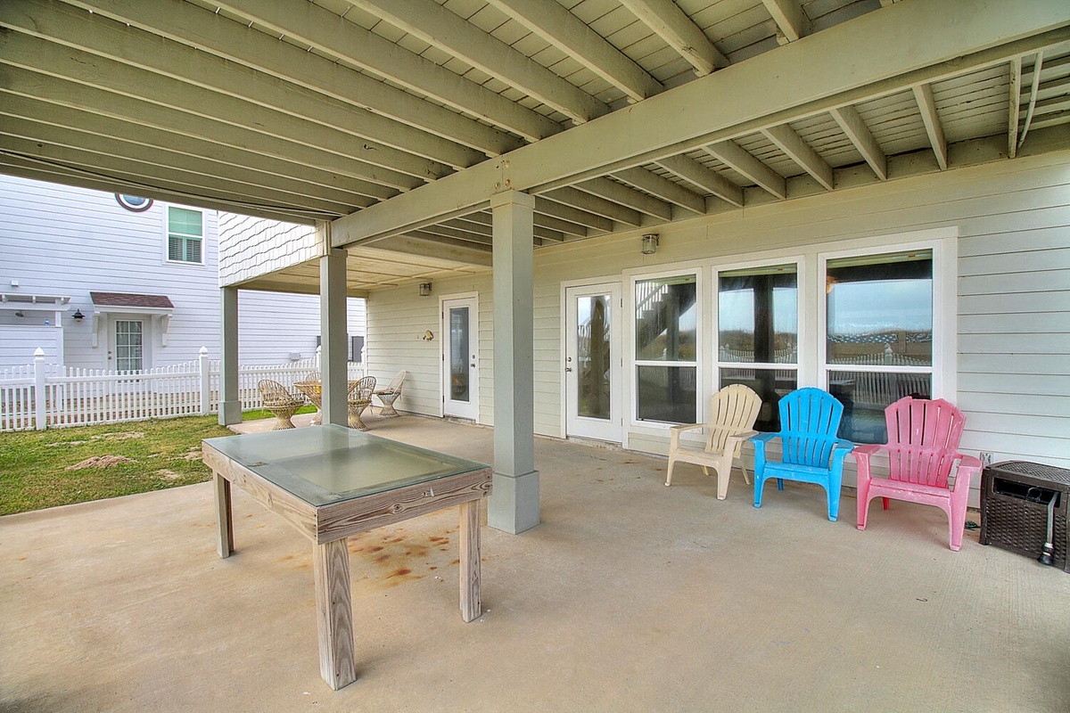 Relax on your private covered patio with colorful Adirondack chairs and outdoor dining table, perfect for morning coffee or evening gatherings.