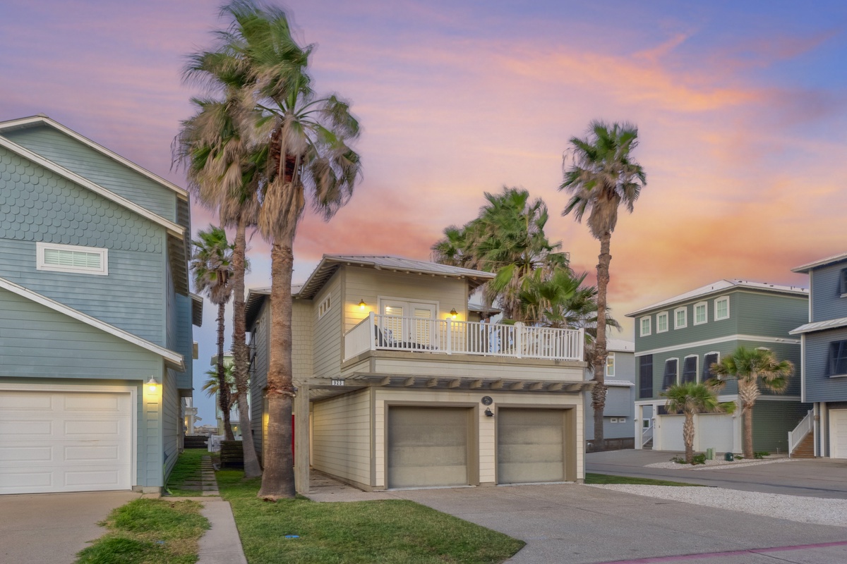Charming coastal retreat nestled among swaying palm trees beneath a stunning twilight sky in this peaceful beachside neighborhood.