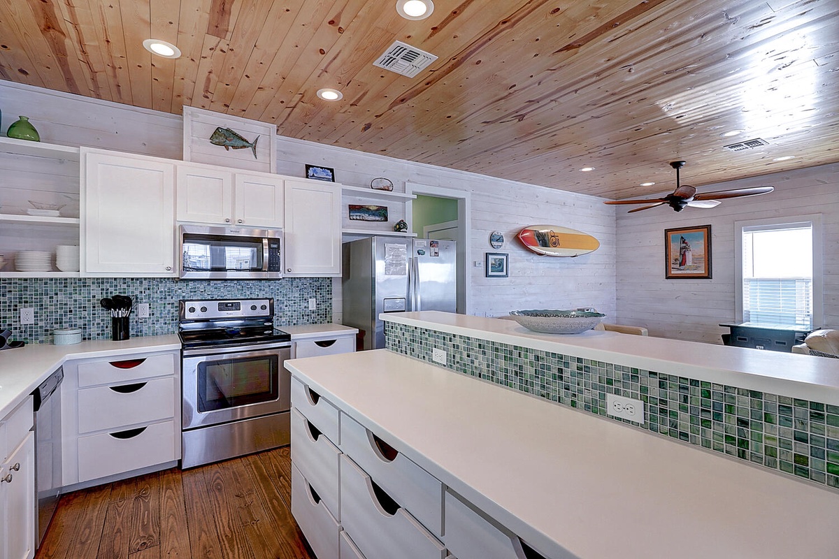 Cook your favorite meals in this stunning coastal kitchen with gorgeous tile backsplash and spacious countertops perfect for gathering.