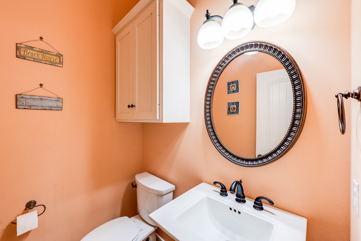 Refresh in your cheerful peach powder room with coastal charm and thoughtful touches throughout.