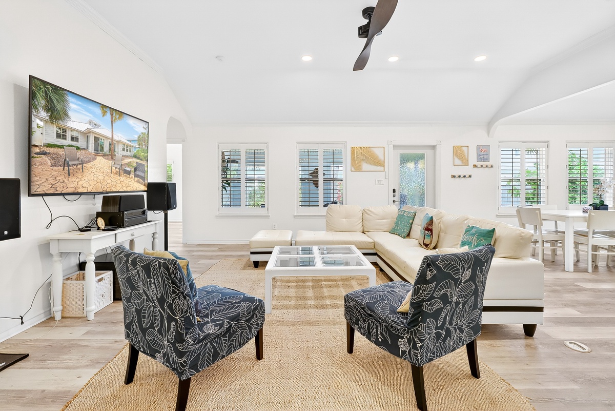 Relax in your bright, airy living space featuring coastal-inspired décor, comfortable seating, and modern entertainment center perfect for unwinding after beach adventures.