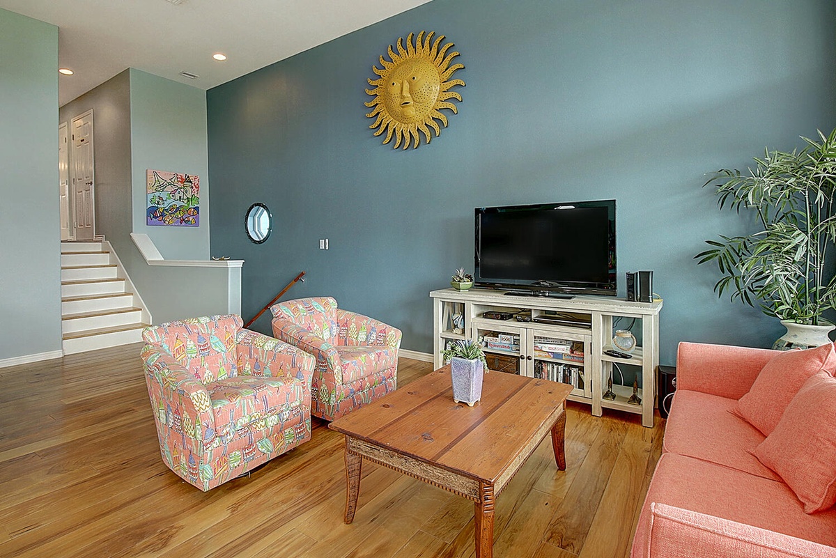 Unwind in your colorful living space featuring vibrant tropical chairs, warm coral sofa, and entertainment center perfect for cozy evenings together.