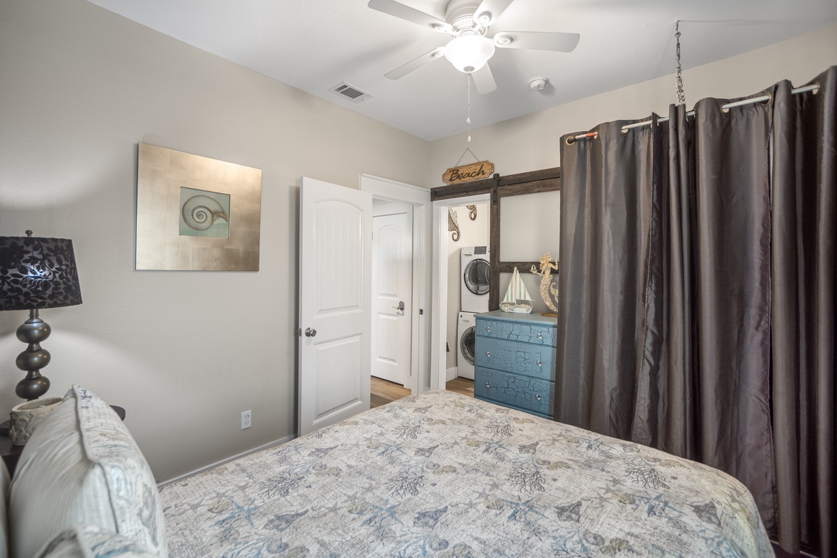 Drift off to sleep in your cozy beach-themed bedroom, complete with ceiling fan and convenient laundry access.