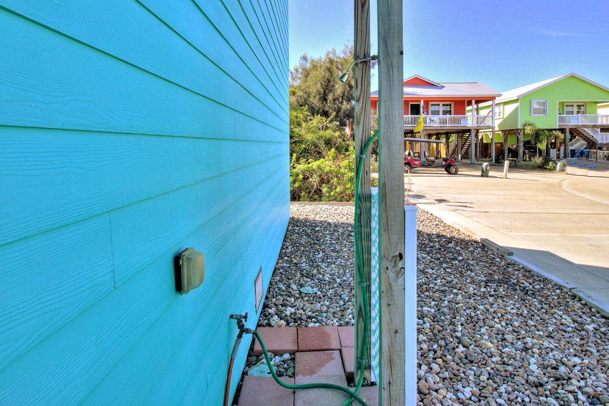 Colorful beachside rental cottages with convenient outdoor shower for rinsing off after sandy adventures.