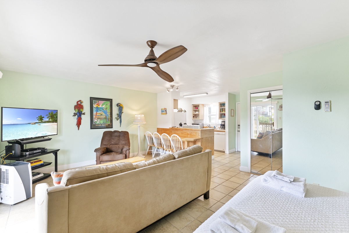 Relax in your bright, airy living space with tropical decor, comfy seating, and an open layout connecting to your fully equipped kitchen.