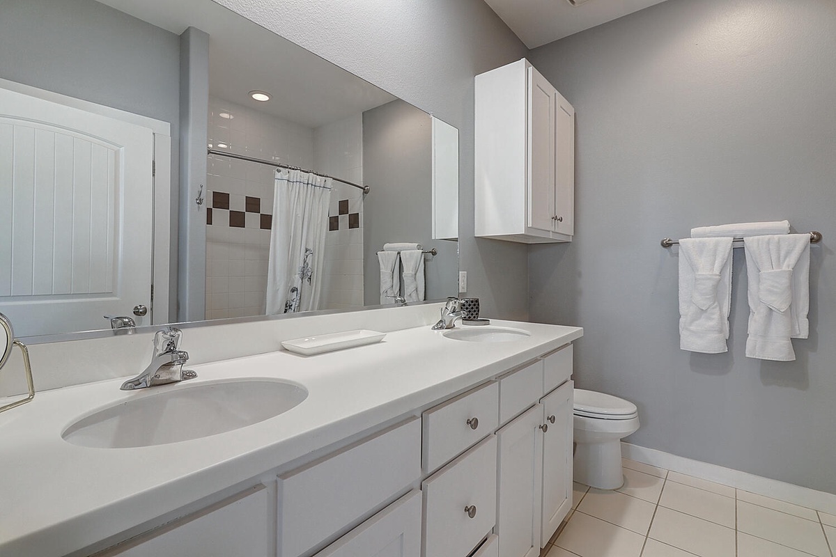Your spacious bathroom features dual sinks, fresh towels, and modern amenities for a comfortable stay.