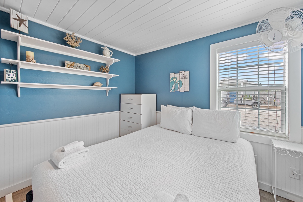 Drift off in your cheerful coastal bedroom featuring soothing blue walls and charming nautical décor that brings beach vibes inside.