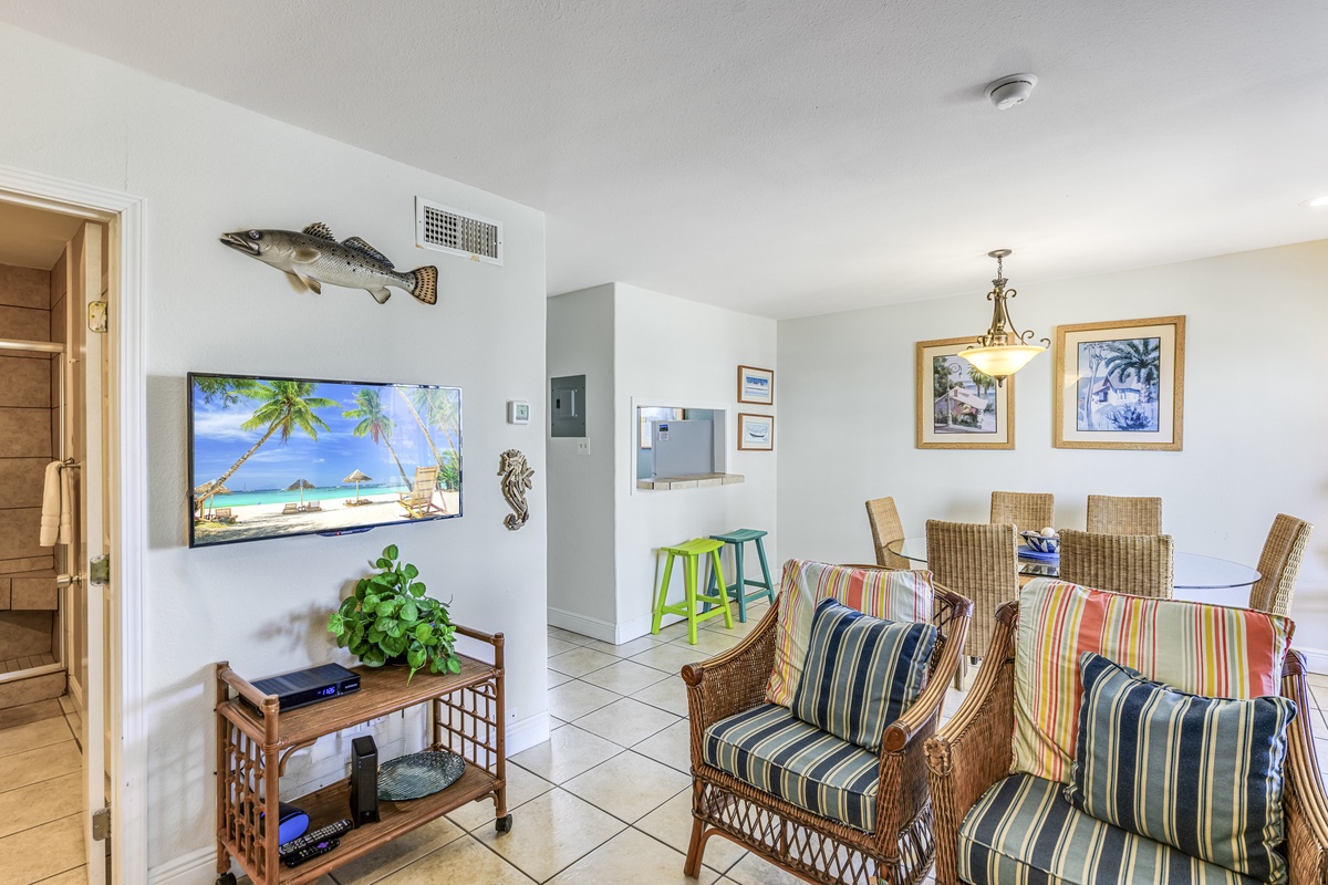 Relax in your coastal-themed living space with tropical décor, comfortable wicker seating, and entertainment center for perfect vacation evenings.