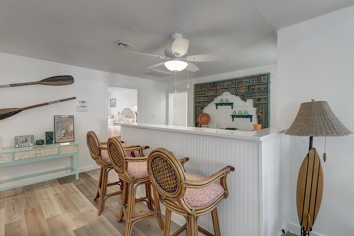 Gather around your coastal-inspired breakfast bar where nautical decor and bamboo stools create the perfect spot for morning coffee and conversation.